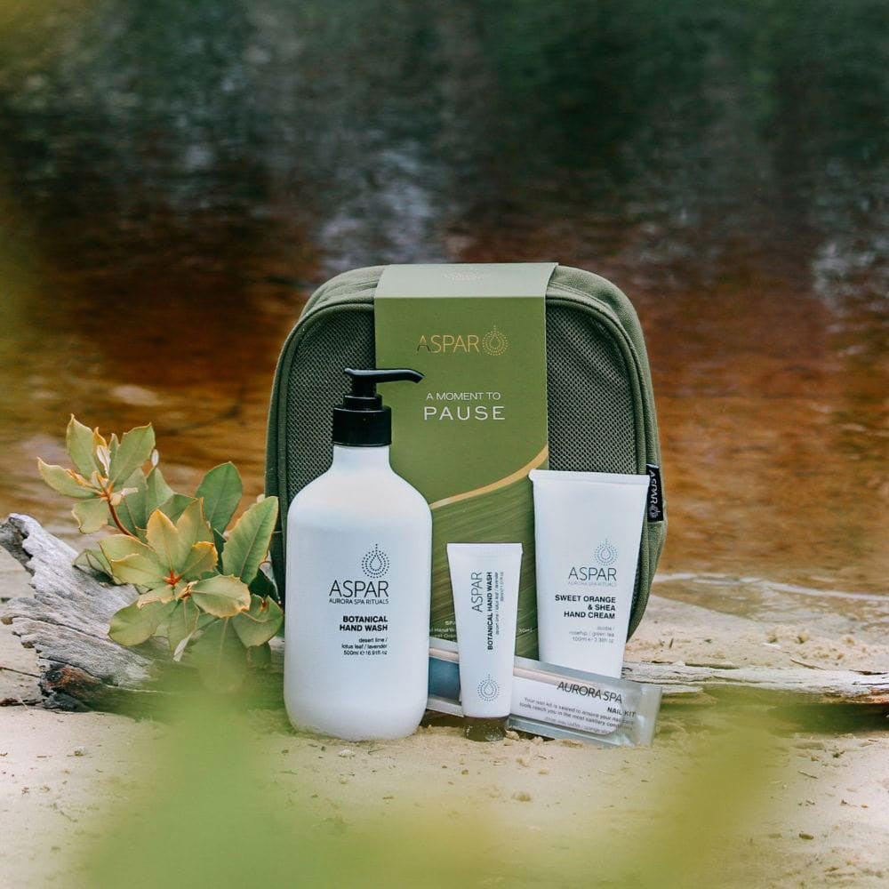 ASPAR skincare products with a green travel case on a natural background
