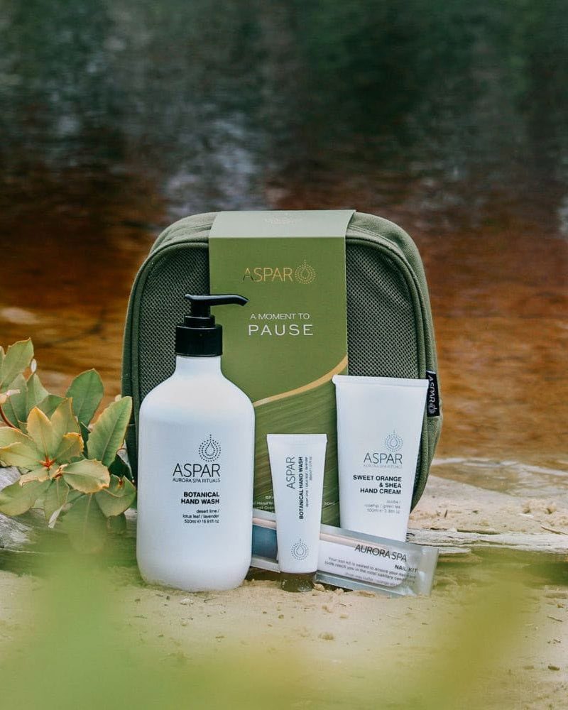 ASPAR skincare products with a green travel case on a natural background