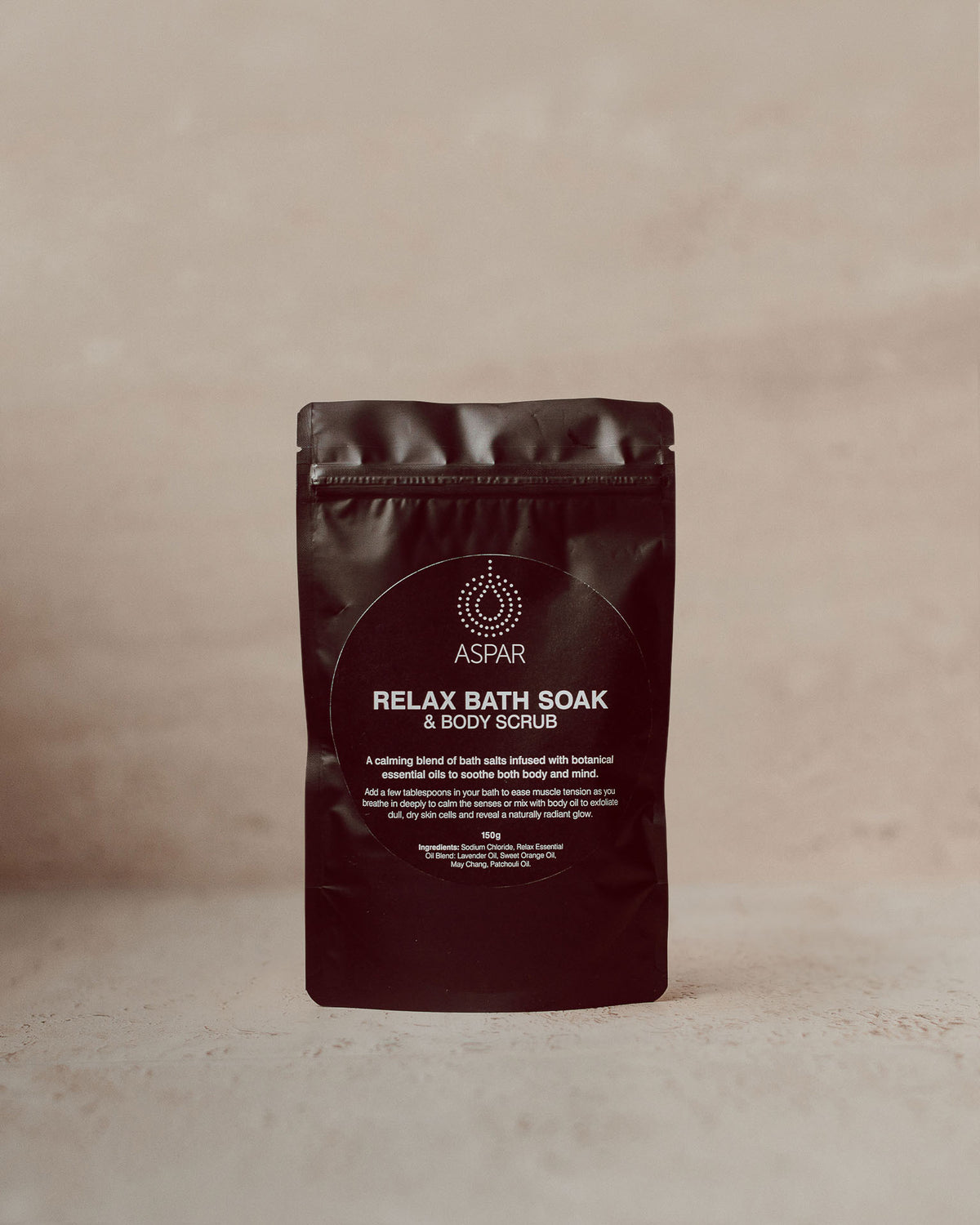 A stand-up pouch of ASPAR Relax Bath Soak & Body Scrub, shown against a neutral, textured beige background.