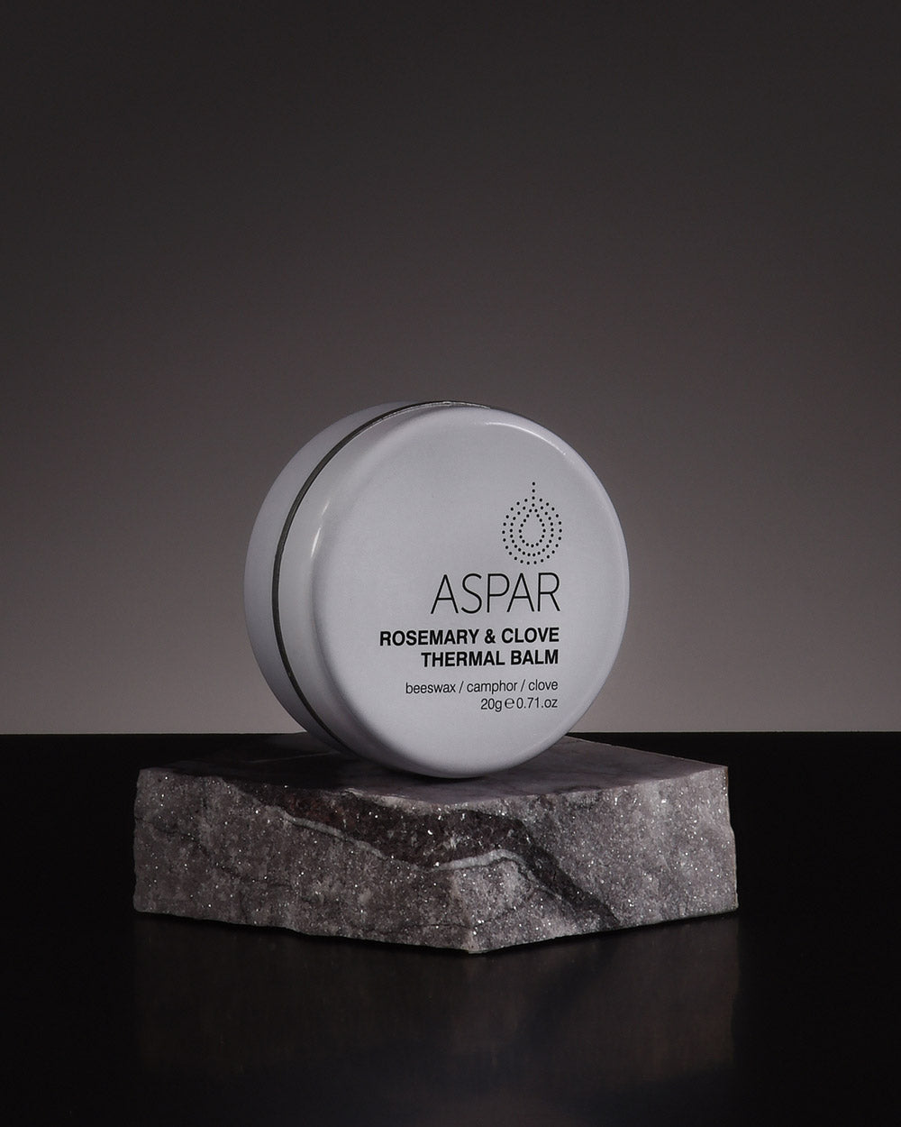 Aspar Rosemary & Clove Thermal Balm on a dark surface with a gray background
