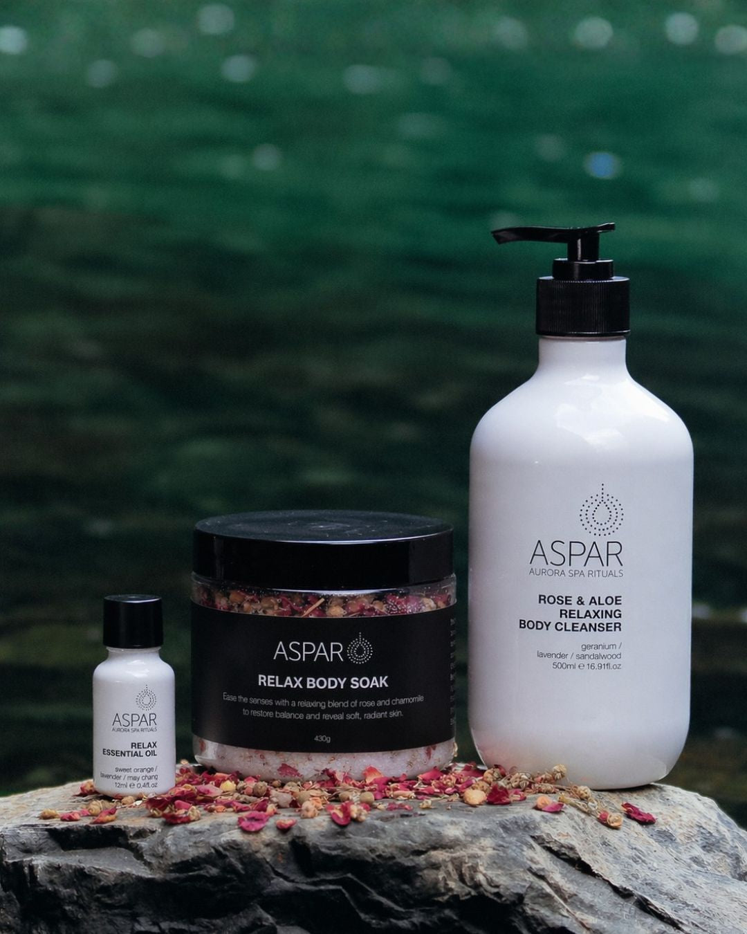Aspar body care products on a rock with a blurred natural background