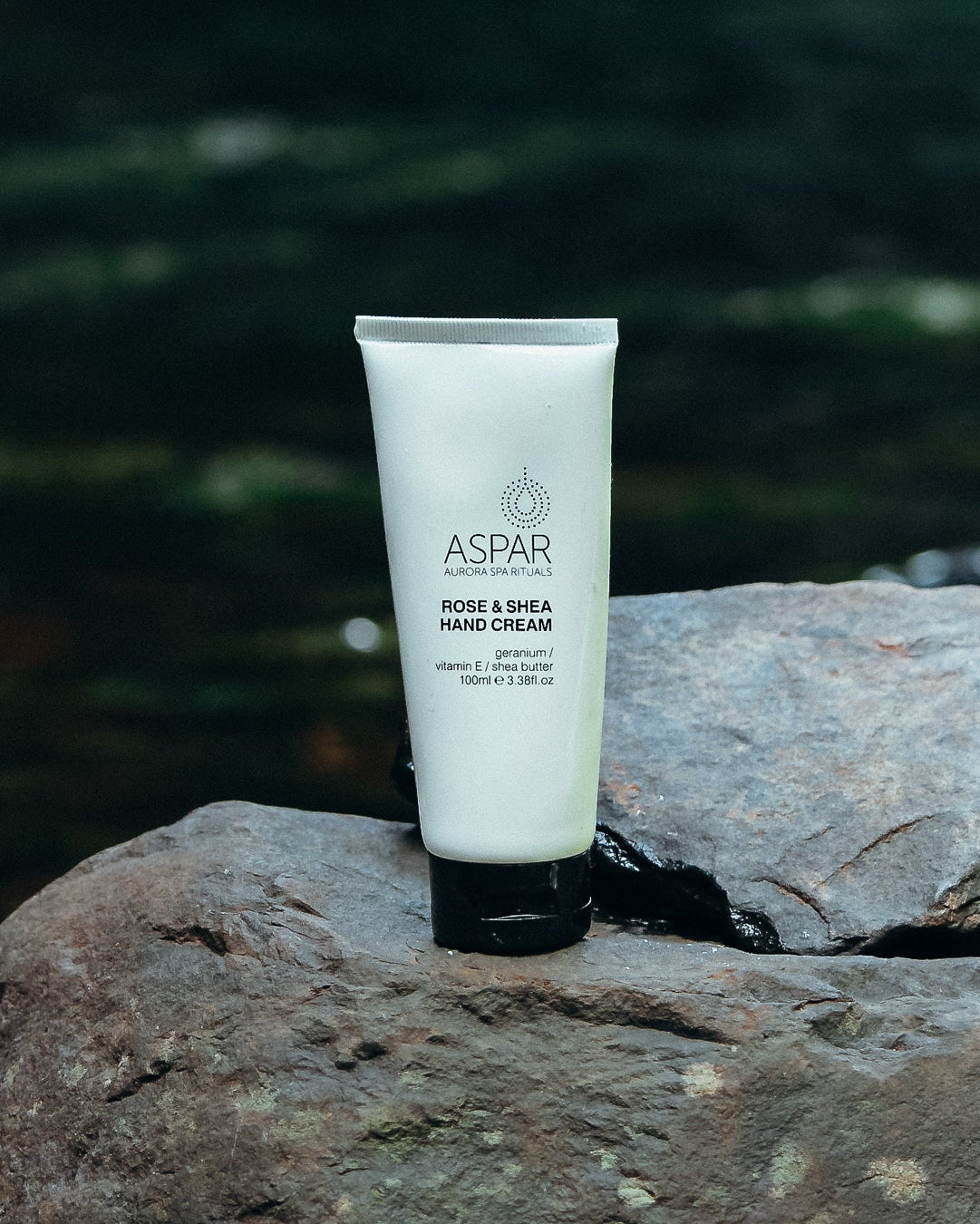 Tube of Aspar hand cream on a rock with a blurred natural background