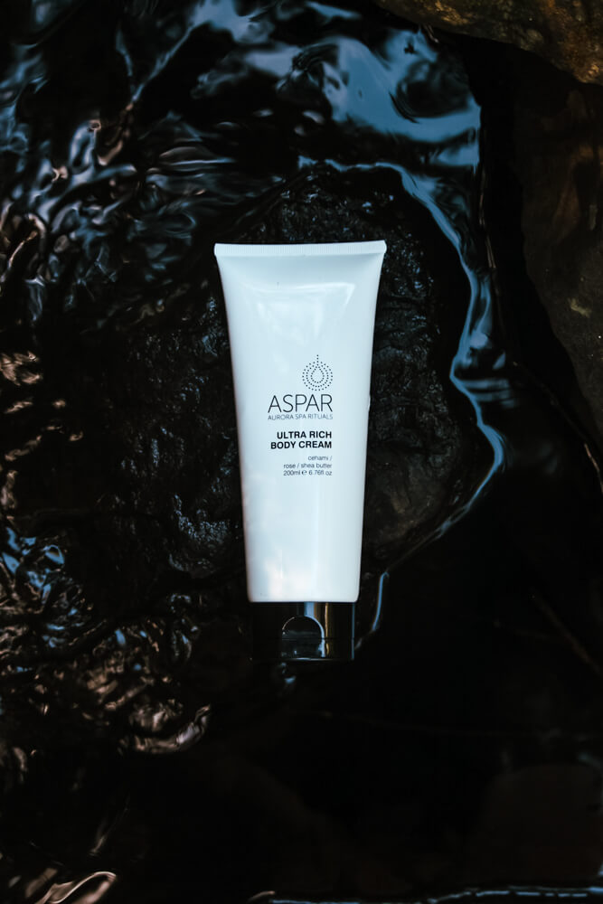 Tube of Aspar Ultra Rich Body Cream on a dark textured background